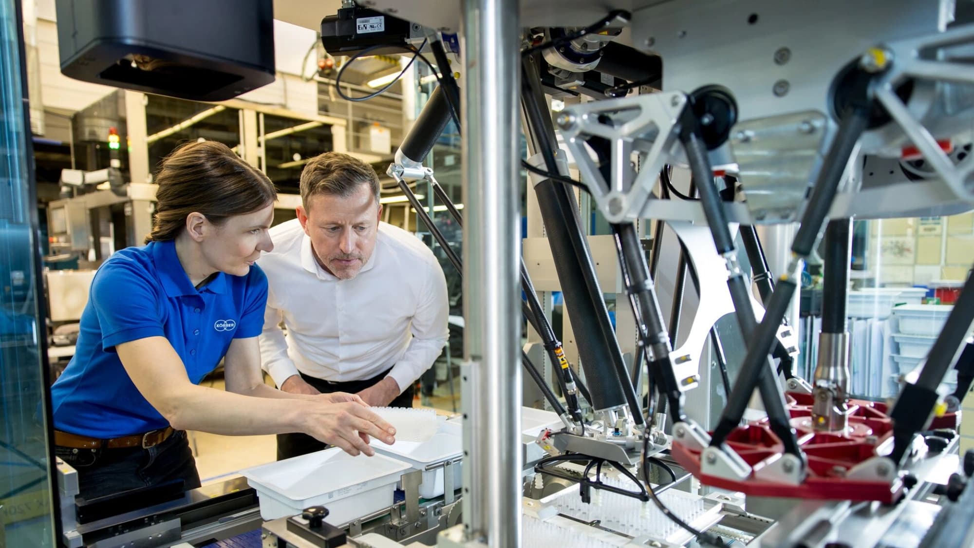 a Körber employee training a client on a pharma machine
