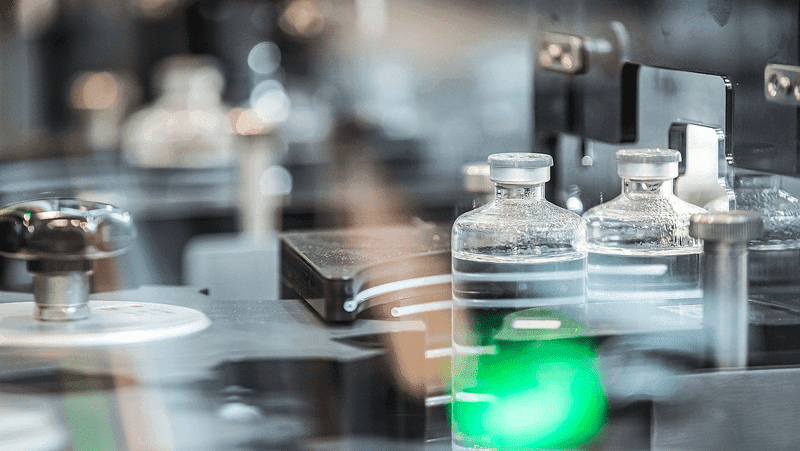 A machine with bottles and items, featuring sensor technology for detecting quality deviations.