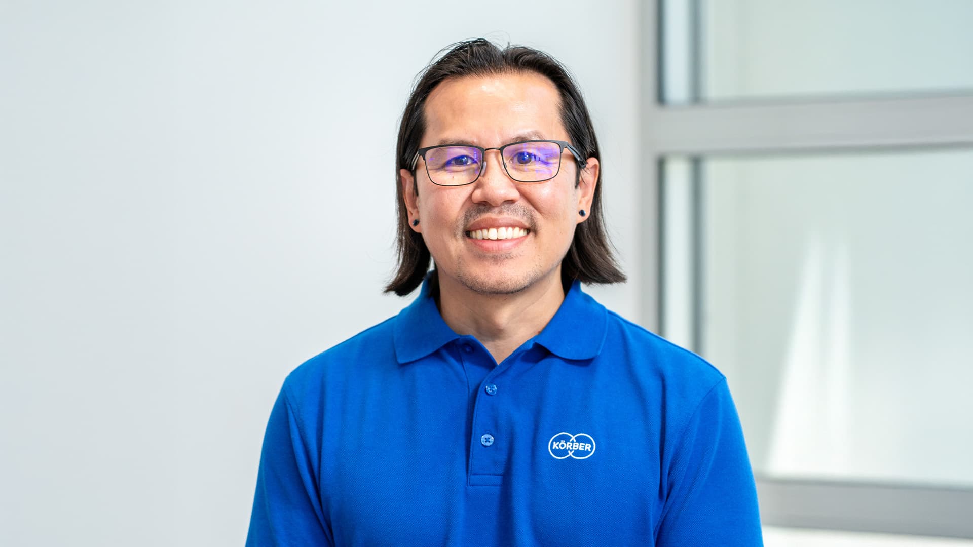 Man wearing a blue Körber branded t-shirt