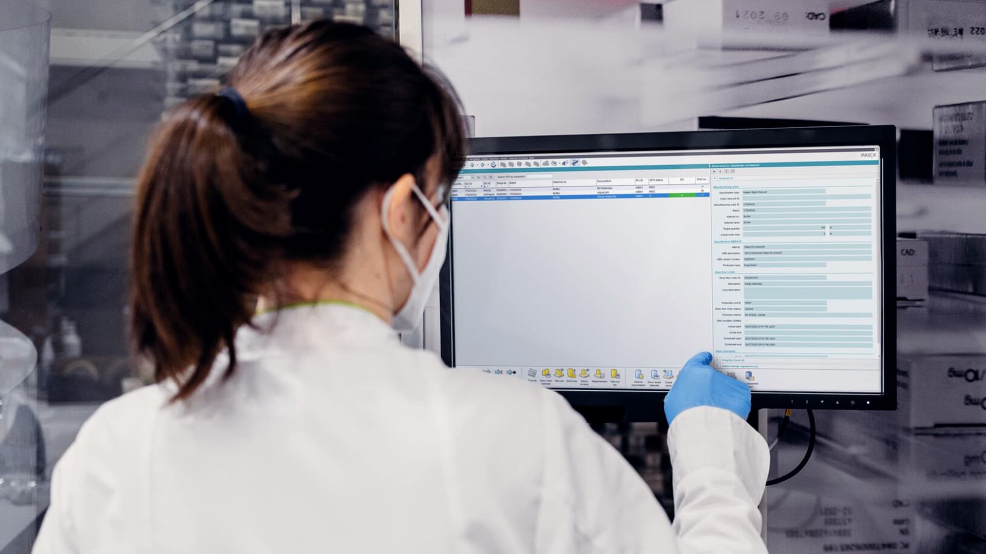 Person wearing personal protective equipment using software on a touchscreen