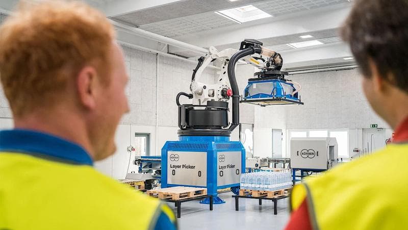 Körber employees examining a machine.