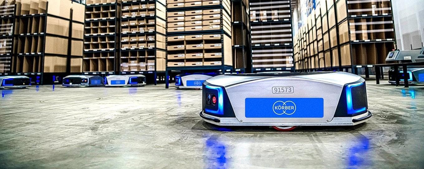 A warehouse filled with several Autonomous Mobile Robots (AMRs) navigating the space efficiently.