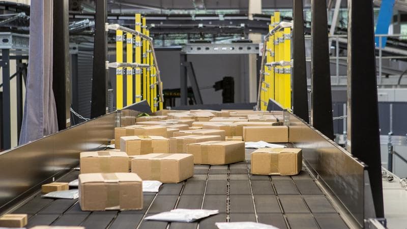 Boxes being transported on belts, part of a machine developed by Körber.