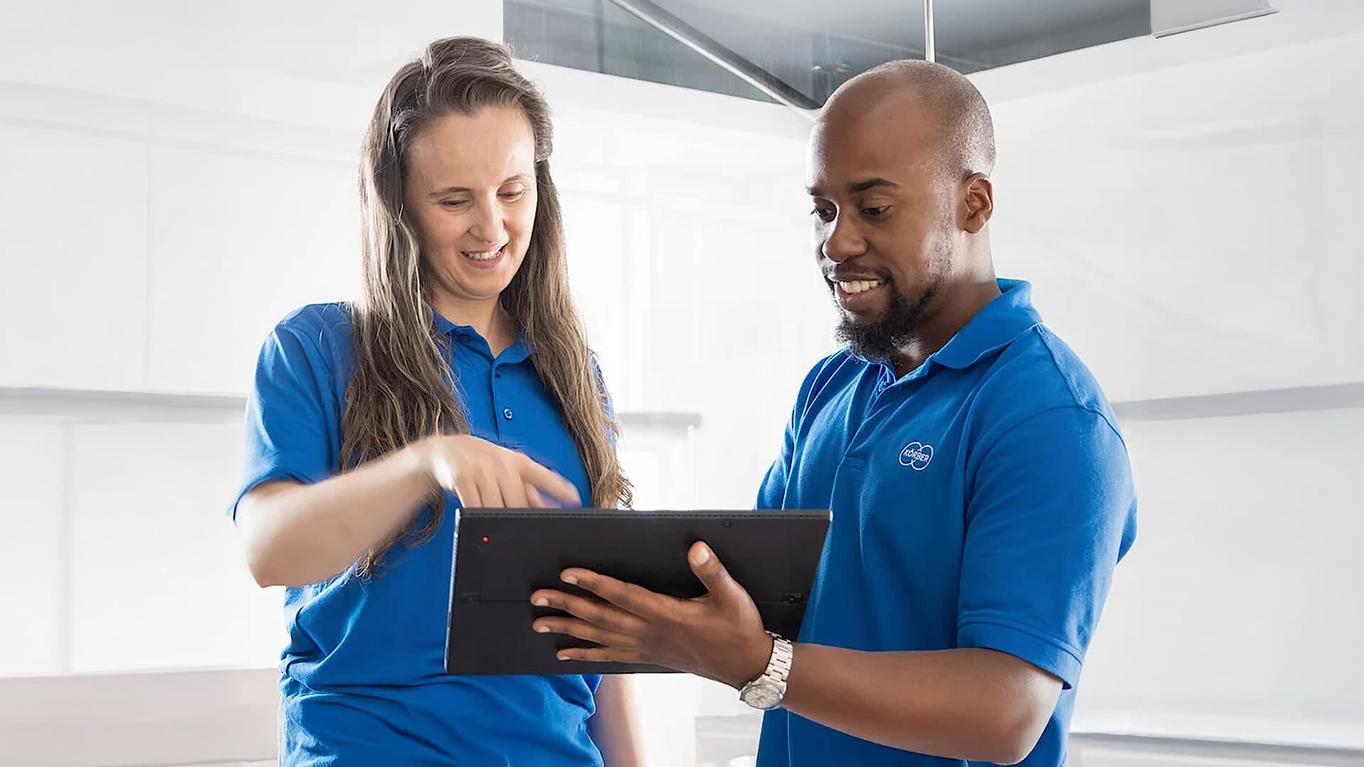 Two Körber employees looking at a tablet device