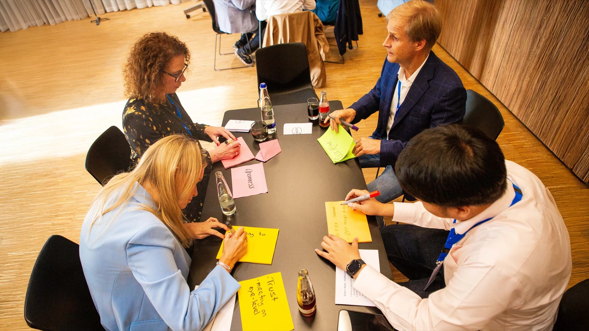 A gathering of people at a table, sharing ideas and interacting with one another.