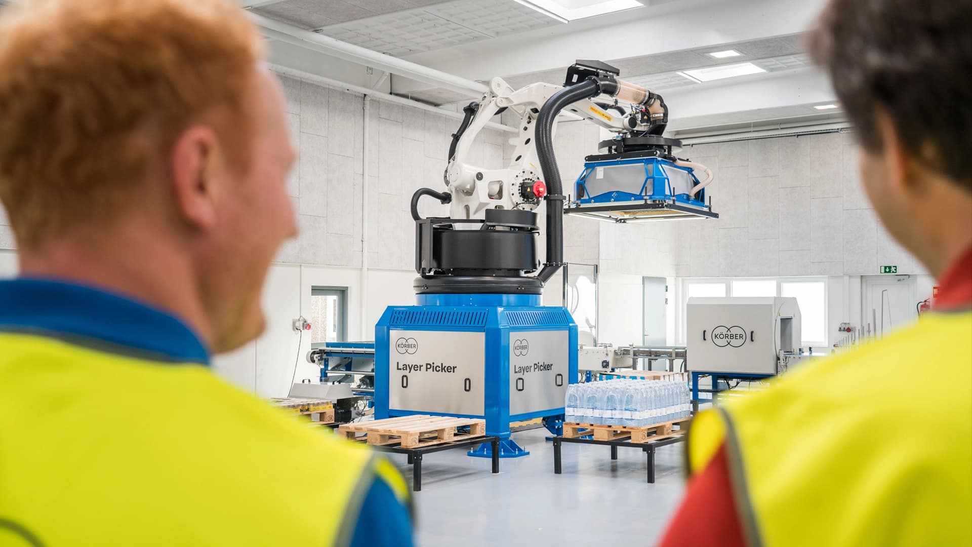 Körber employees examining a machine.