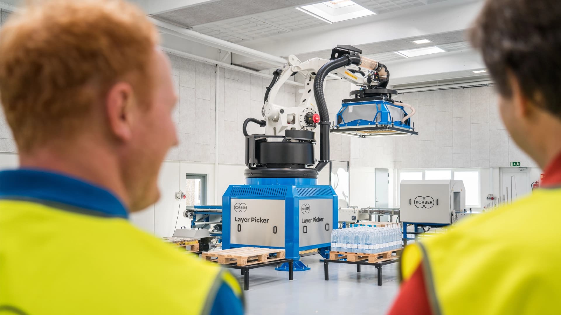 Two Körber employees near the Layer Picker machine