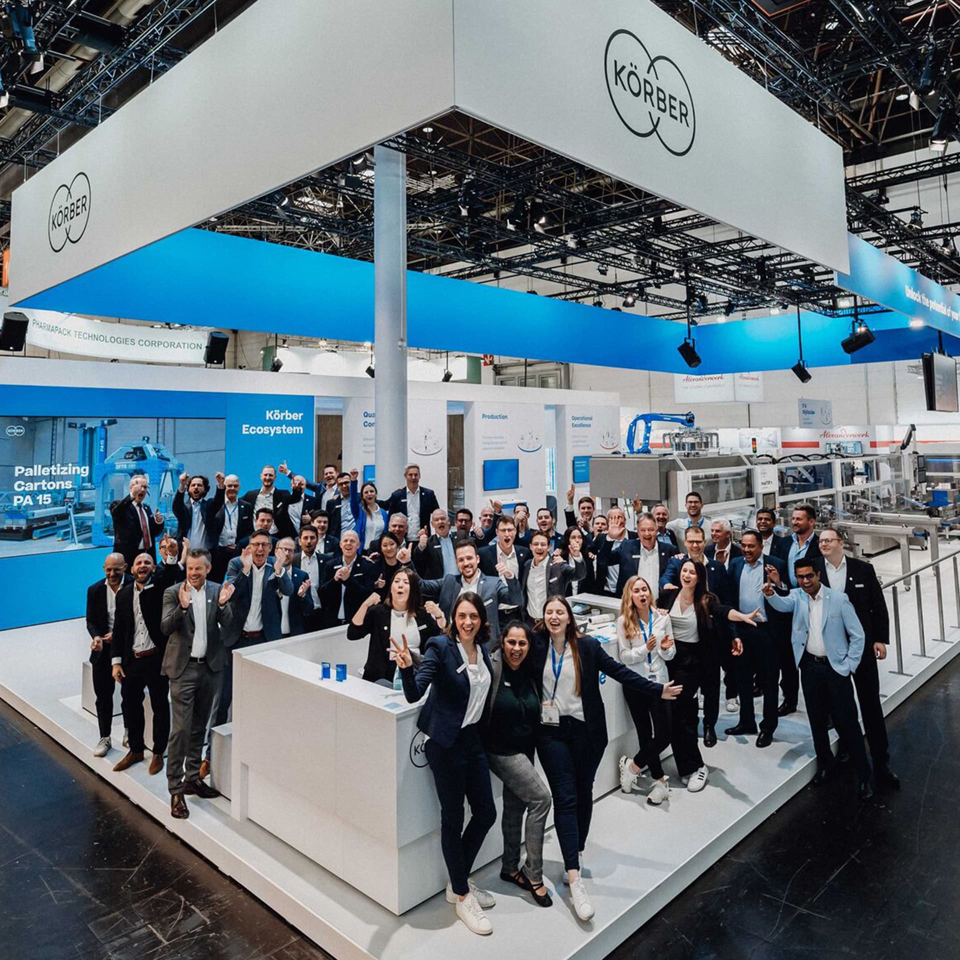 Group shot of Körber employees at a branded trade show stand