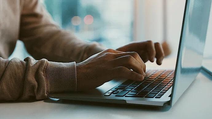 A person typing on a laptop