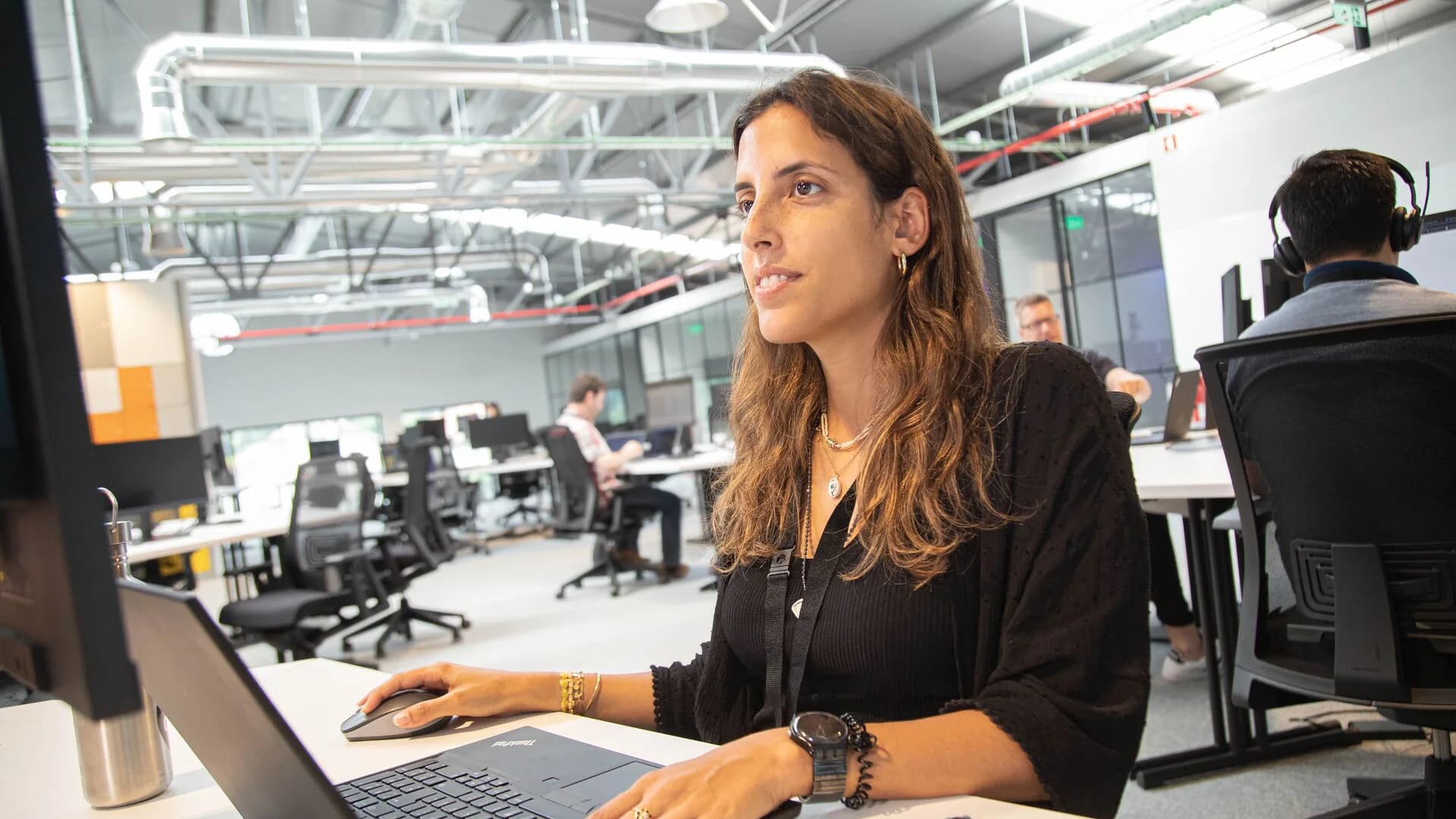 A woman seated at a desk using a laptop in the Körber Cyber Defense Center