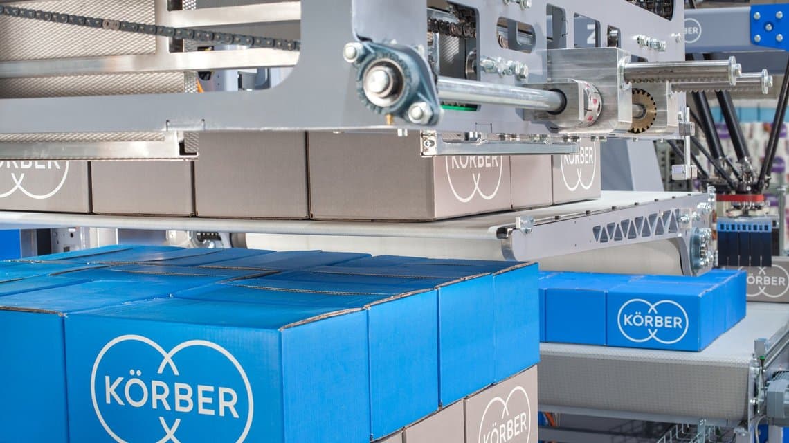 Photograph of the PA15 layer palletizer, a modular industrial machine featuring a tiered platform and conveyor, designed for scalable automation in pallet logistics.