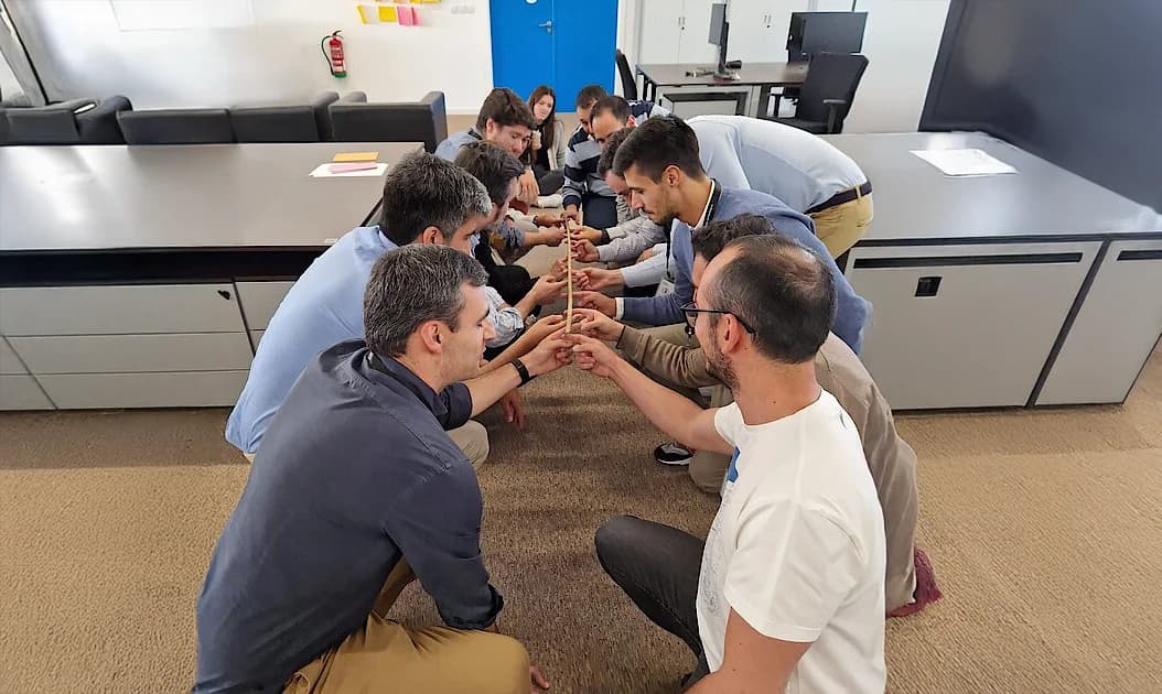 Group of employees doing a team building activity in an office space.