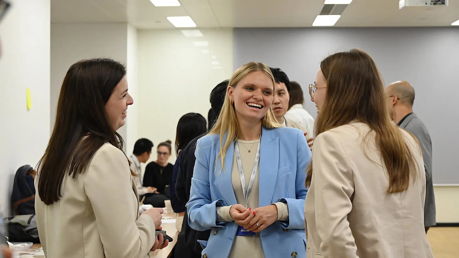 A diverse group of people engaged in conversation at a networking event, sharing ideas and experiences.