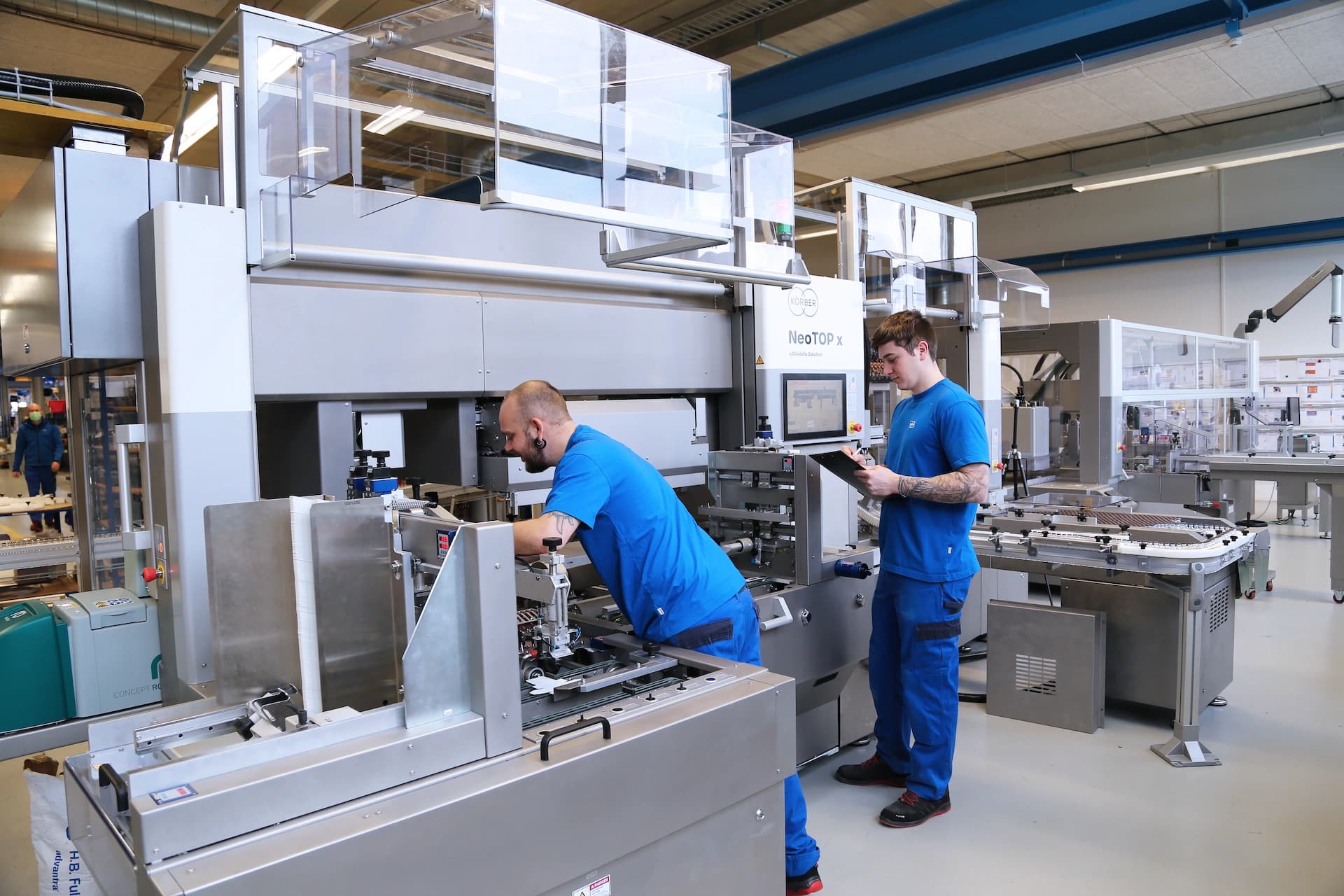 two Körber employees working on a pharma machine