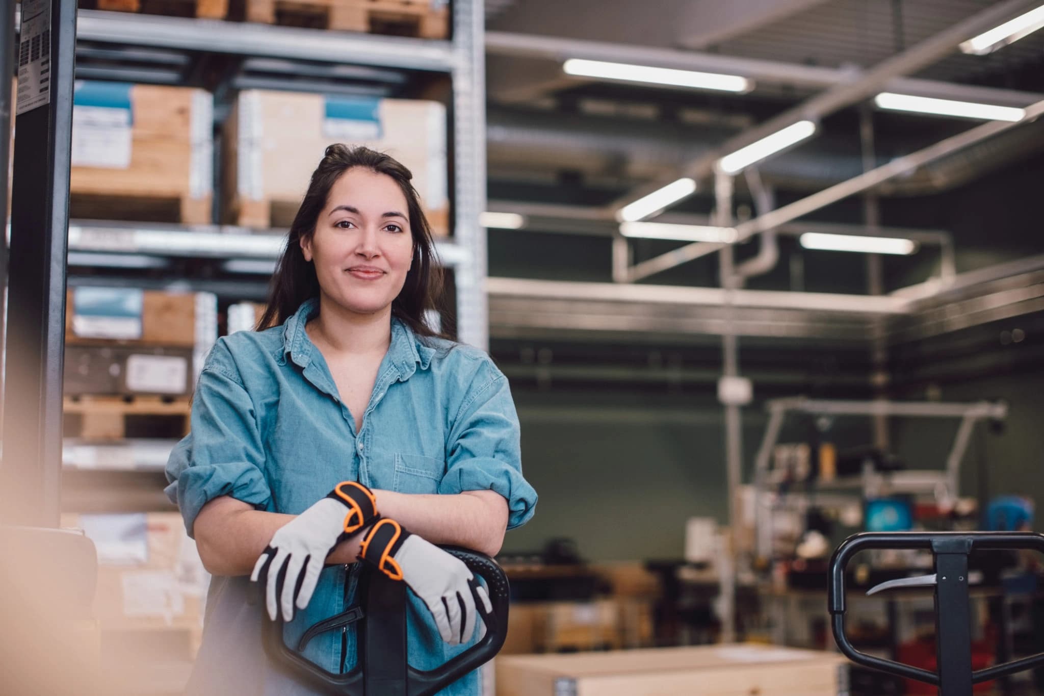 Female operator in an industrial warehouse setting.