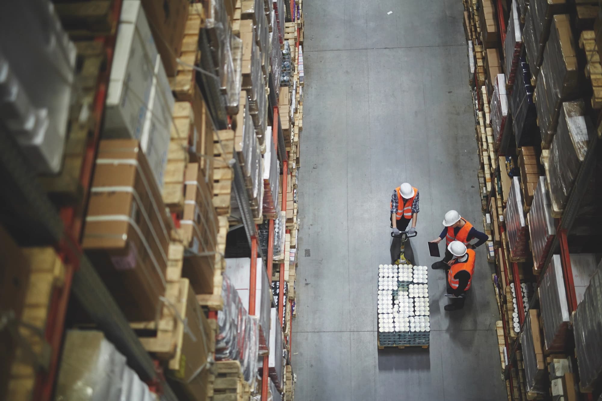 two workers doing manual handling in a warehouse setting