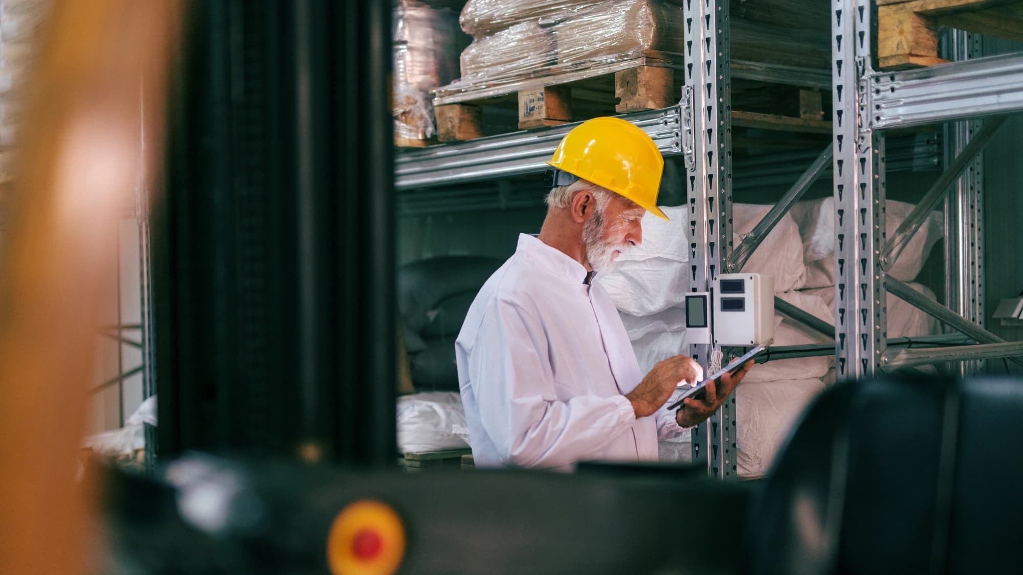 a man wearing safety gear working on inventory on a warehouse