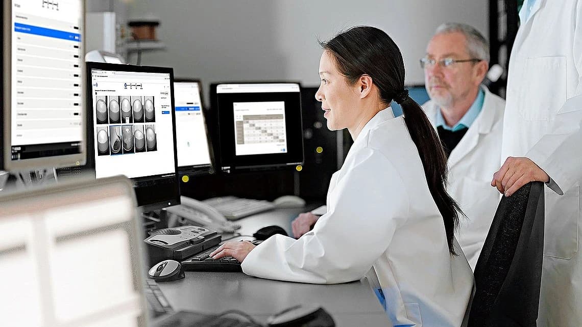 Photo of professional analyzing inspection processes on a computer.