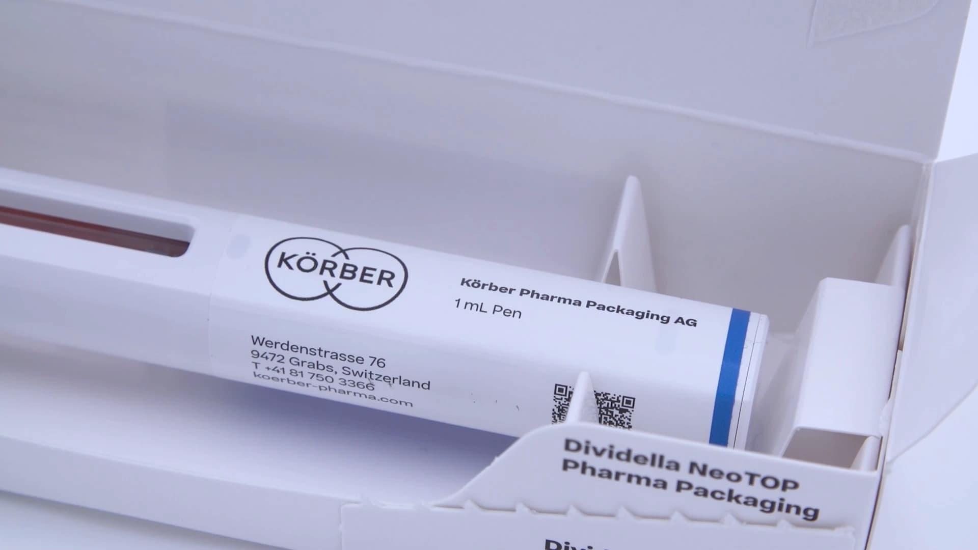 Picture of a pen being packed in a box assembled by the Dividella NeoTOP solution.