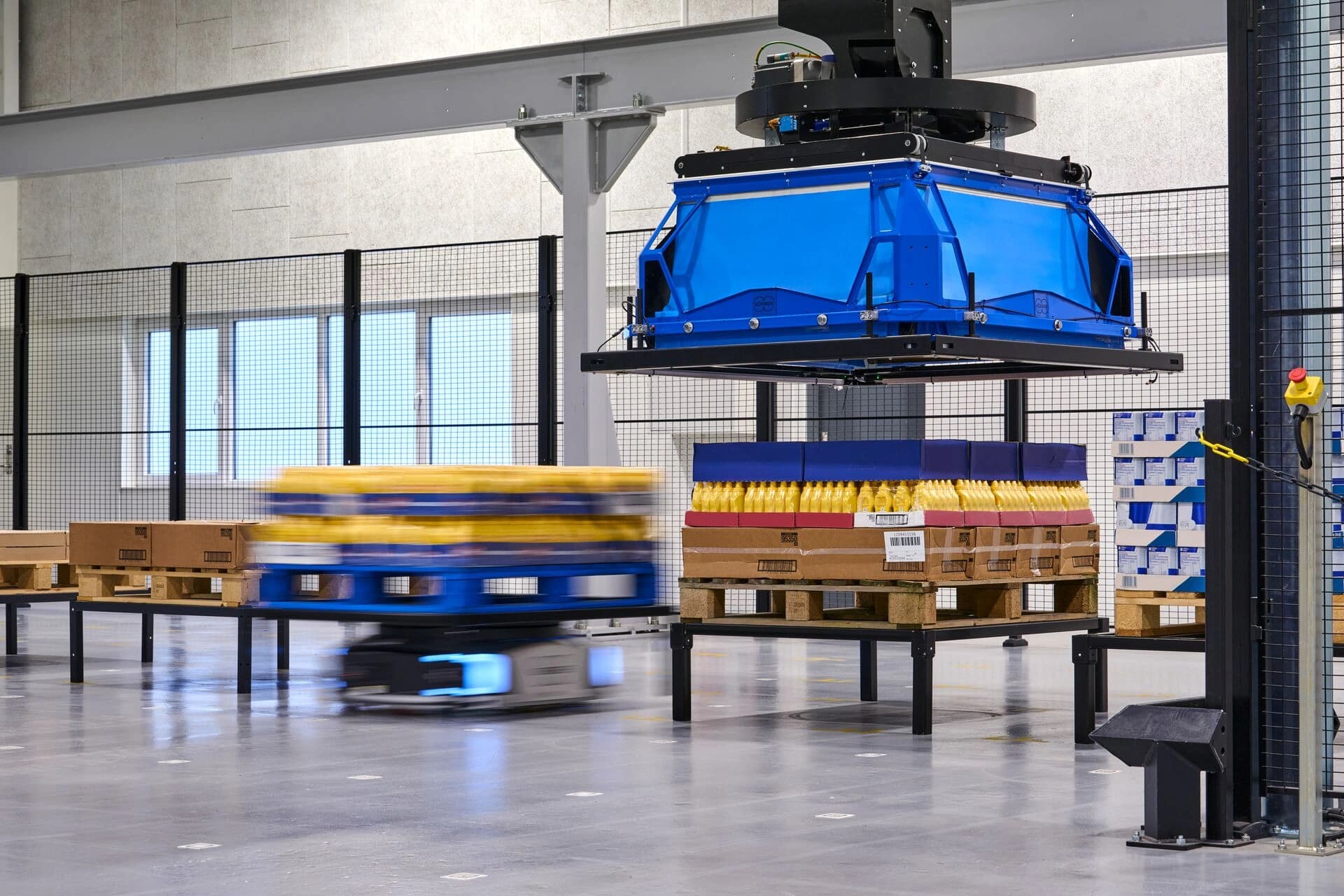 layer picker robot and autonomous mobile robot in action in a warehouse environment