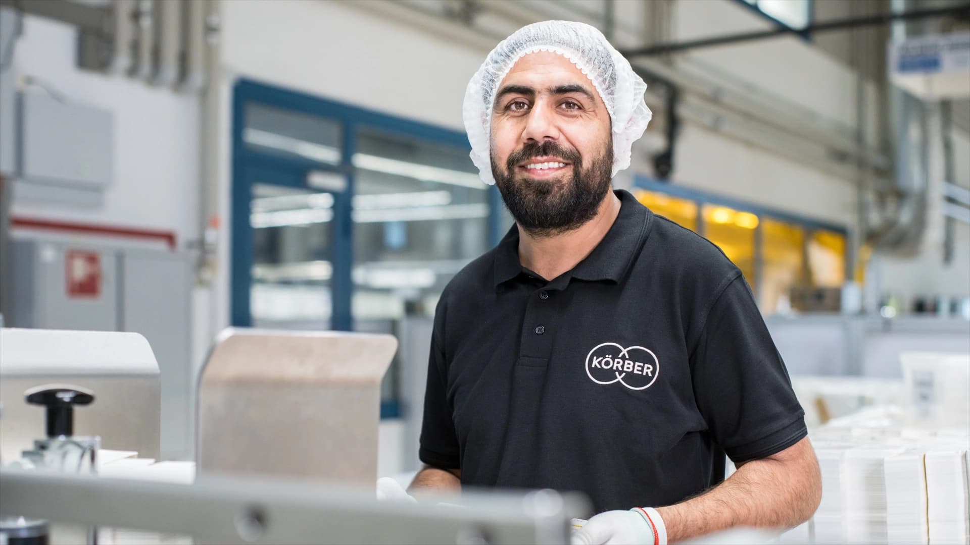 Smiling man in a black shirt and hat, showcasing the partnership between Bähren Pharma-Packaging and Körber.